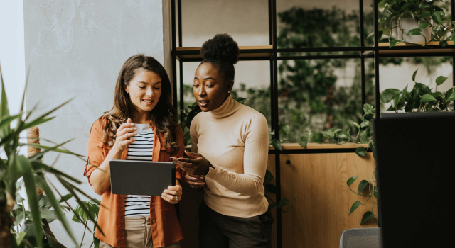 two young business women with digital tablet standing modern office