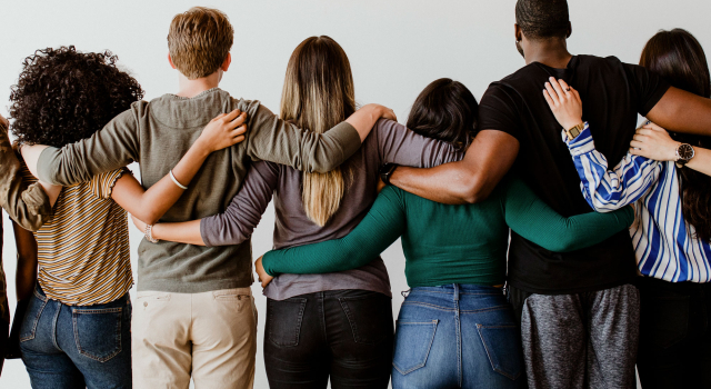 rearview diverse people hugging each other