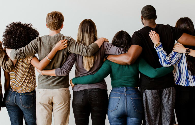 rearview diverse people hugging each other