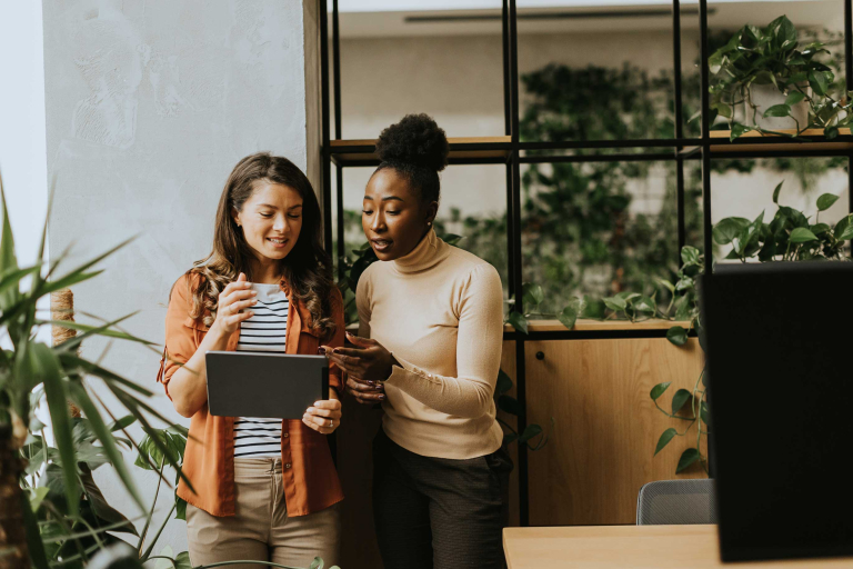 two young business women with digital tablet standing modern office